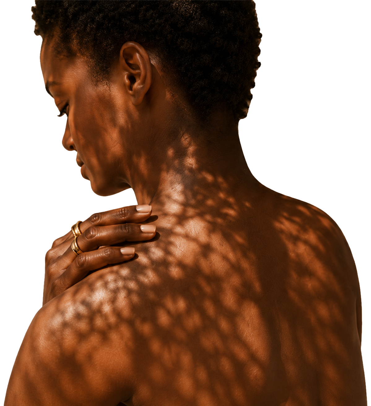 Black woman resting a ringed hand on her shoulder in warm dappled light.